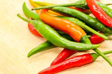 Closeup ahşap arka plan üzerinde kırmızı, turuncu ve yeşil biber