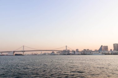 Tokyo'daki sumida nehir bakış açısı, bir tekne ve Gökkuşağı Köprüsü