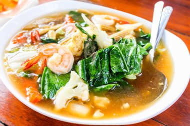 Beyaz çanak üzerinde deniz ürünleri ve brokoli ile Kızarmış erişte yakın