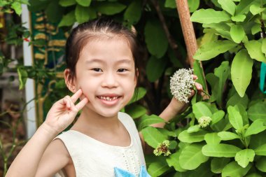 Sevimli kız ve beyaz çiçek spike Rubiaceae mahs coccinea bahçede tek closeup
