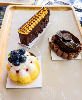 Ahşap plaka üzerinde üç tasarım sevimli küçük pasta Closeup