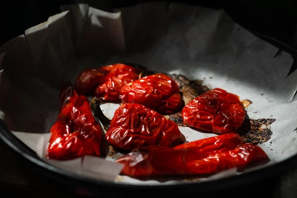 Round fresh red licorice peppers on a dark background