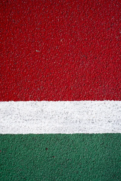 Asphalt in white red and green. White stripe in the middle. Vertical orientation