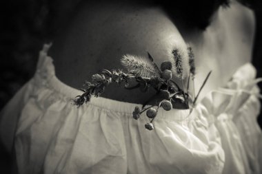 Çıplak omuzlu beyaz bluz. Küçük bir buket. Monokrom. Yatay yönlendirme.