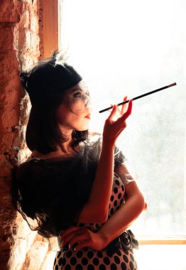 Siyah şapkalı, elinde bir ağızlıkla pencerenin kenarında duran ve aşkını düşünen sevimli bir yabancının portresi. Gatsby tarzı parti.