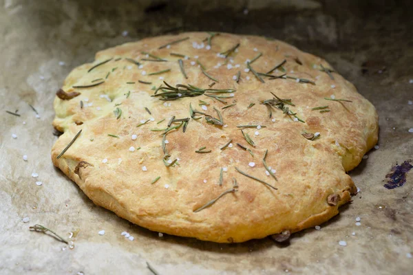 Taze İtalyan Focaccia ve parşömen üzerinde deniz tuzu ve biberiye.