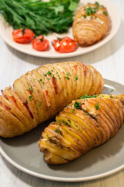 Domatesler ve fırında pişirilmiş taze otlar ve folyoda patates.