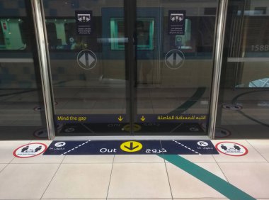 Dubai, Birleşik Arap Emirlikleri- 30 Nisan 2020: Dubai Metro Treni 'nin zemininde farkındalık çıkartmaları, yolcuları Arap araçları ile güvenli mesafeyi koruyarak COVID-19' un yayılmasını önlemeyi talep ediyor.