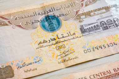 BAE 200 dirhem para birimi notlarını yüksek açılı ve kağıt paralı hafif ahşap masaya yakın çekim