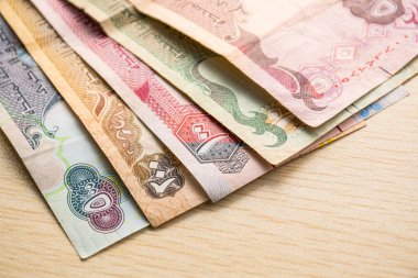 Farklı BAE kara para birimlerinin kapatılması, yüksek açılı beyaz bir masa üzerindeki kağıt para.