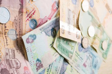 Farklı BAE dirhams döviz notları ve bozuk paralar, yüksek açılı beyaz bir masa üzerindeki kağıt para