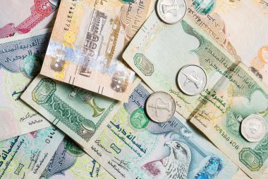 Farklı BAE dirhams döviz notları ve bozuk paralar, yüksek açılı beyaz bir masa üzerindeki kağıt para
