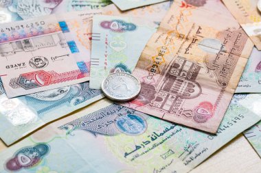 Farklı BAE dirhams döviz notları ve bozuk paralar, yüksek açılı beyaz bir masa üzerindeki kağıt para