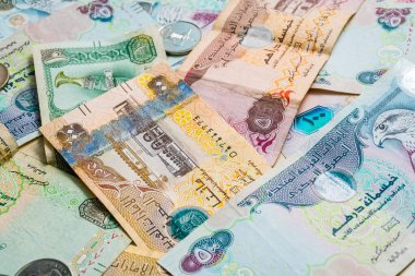 Farklı BAE dirhams döviz notları ve bozuk paralar, yüksek açılı beyaz bir masa üzerindeki kağıt para