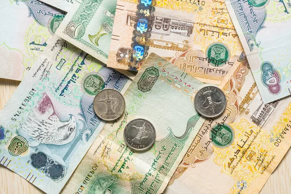 Farklı BAE dirhams döviz notları ve bozuk paralar, yüksek açılı beyaz bir masa üzerindeki kağıt para