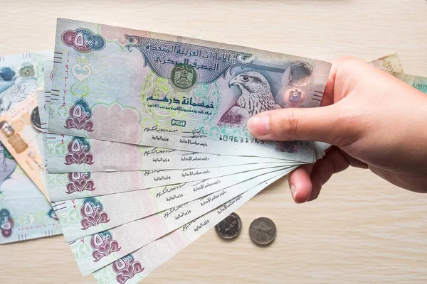 Uae 500ディルハムの通貨ノートを保持している少女の手の閉鎖 軽い背景に対する紙幣 — ストック写真