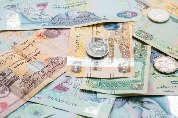 Farklı BAE dirhams döviz notları ve bozuk paralar, yüksek açılı beyaz bir masa üzerindeki kağıt para