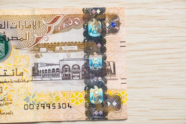 BAE 200 dirhem para birimi notlarını yüksek açılı ve kağıt paralı hafif ahşap masaya yakın çekim