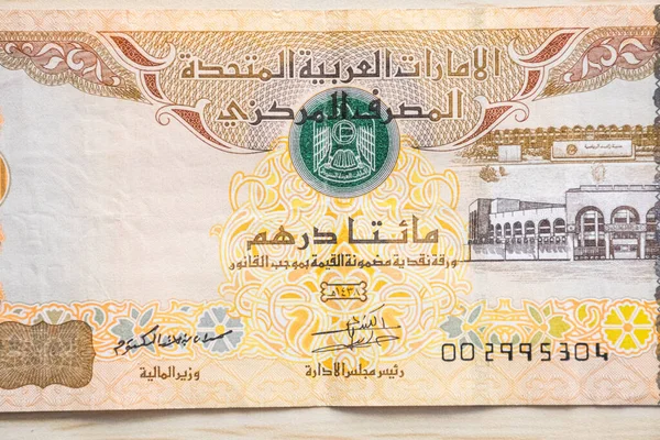 BAE 200 dirhem para birimi notlarını yüksek açılı ve kağıt paralı hafif ahşap masaya yakın çekim