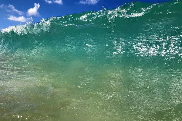 turquoise water tube wave crashing on seashore.