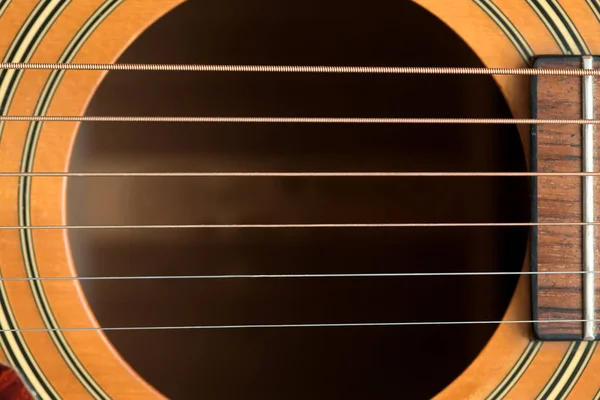 Akustik ahşap gitar altı perde ve ses deliği yakın makro görünümü