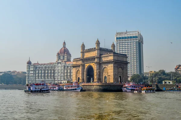 Hermosa puerta de entrada de la India cerca del hotel Taj Palace en el puerto de Mumbai con muchos embarcaderos en el mar Arábigo — Foto de Stock