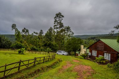 Sabie Güney Afrika'da güzel bir günlük ahşap kabin evi yerli çam ormanı ve yeşillik bakan
