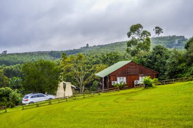 Sabie Güney Afrika'da güzel bir günlük ahşap kabin evi yerli çam ormanı ve yeşillik bakan