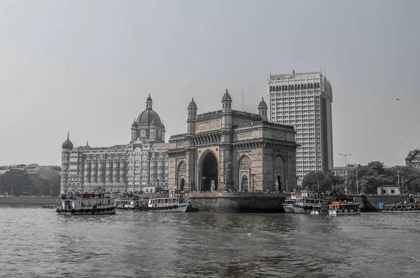 Hermosa puerta de entrada de la India cerca del hotel Taj Palace en el puerto de Mumbai con muchos embarcaderos en el mar Arábigo — Foto de Stock