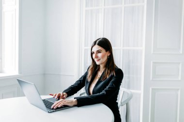 Koyu renk elbiseli kız, takım elbiseli, dizüstü bilgisayar, avukat, danışman, uzman, ofiste ve evden, internetten, iş arkadaşlarıyla iletişim kuruyor.