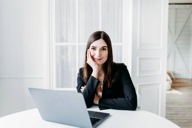 Koyu renk elbiseli kız, takım elbiseli, dizüstü bilgisayar, avukat, danışman, uzman, ofiste ve evden, internetten, iş arkadaşlarıyla iletişim kuruyor.