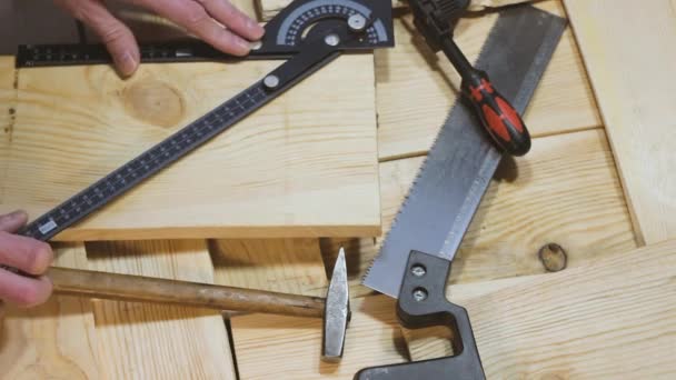 Marteau, scie et pince reposent sur un fond en bois. Outils de construction — Video