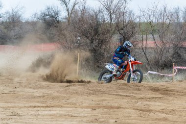 Kalach-on-Don, Rusya - 6 Nisan 2019: Rusya'nın Volgograd bölgesinden katılımcılar arasında motokros yarışması, bilinmeyen binici motosikletine biniyor ve tekerleklerin altından tozu yükseltiyor