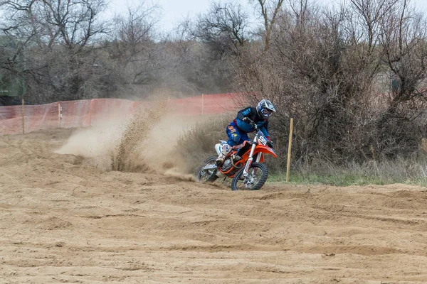 Kalach-on-Don, Rusland-6 april 2019: motorcross competitie tussen deelnemers uit de regio Volgograd van Rusland, onbekende ruiter rushes op zijn motorfiets en verhoogt het stof van onder de wielen — Stockfoto