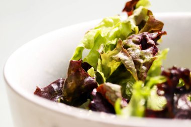 Beyaz bir kase taze yeşil salata yaprakları