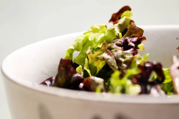 Beyaz bir kase taze yeşil salata yaprakları