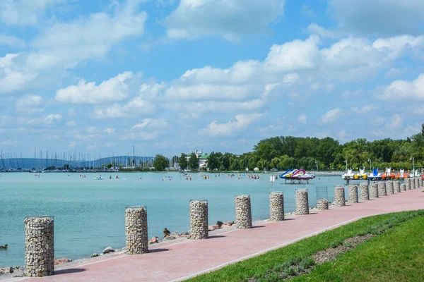 A vitorlás hajók és vízibiciklik, a tó gyönyörű strand — Stock Fotó