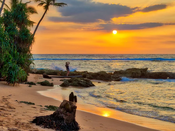 A gorgeous sundown with warm and luminous colors in gold, orange, red, over the wild Indian Ocean in Asia on the fascinating tropical island Sri Lanka