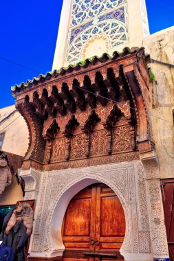 Eski tarz bir cami girişi ve Fas, Kuzey Afrika 'daki Fes şehrinde muhteşem ahşap bir kapı ve mozaik süsler.