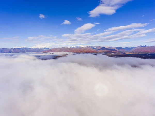 Denali and Alaska Range mountains aerial view over the cloud in fall, near Denali State Park, Alaska AK, USA.