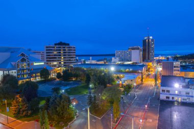 Anchorage şehir merkezinde Alaska Sahne Sanatları Merkezi, Town Square Park ve gece Anchorage 'daki Hilton Anchorage Hotel binası da dahil olmak üzere hava manzaralı.. 