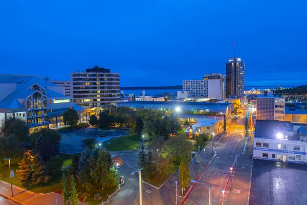 Anchorage şehir merkezinde Alaska Sahne Sanatları Merkezi, Town Square Park ve gece Anchorage 'daki Hilton Anchorage Hotel binası da dahil olmak üzere hava manzaralı.. 