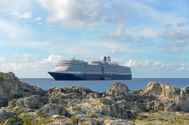 Holland American Line Cruise ship Nieuw Amsterdam anchore offshore in Half Moon Cay (Little San Salvador Island), Bahamas. clipart
