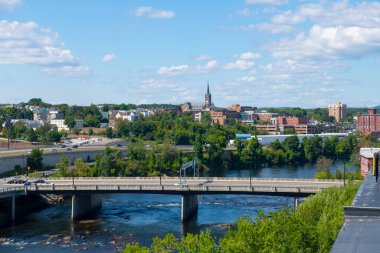 Manchester tarihi şehir silueti Merrimack Nehri, Granite Caddesi Köprüsü ve Manchester, New Hampshire NH, ABD 'deki West Side Sainte Marie Parish kilisesi de dahil olmak üzere. 