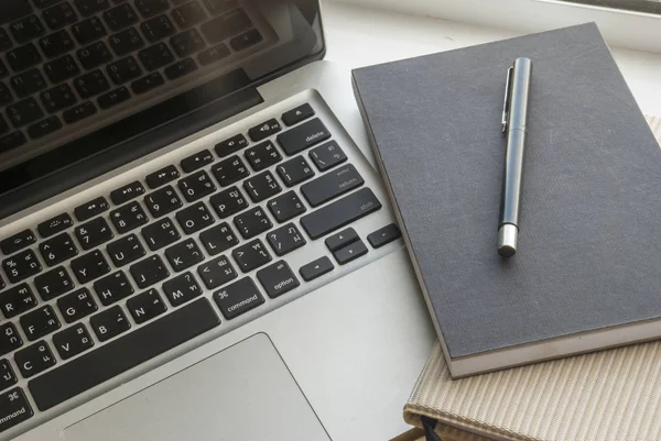 Espacio de trabajo para ordenador portátil con cuadernos y bolígrafos —  Fotos de Stock