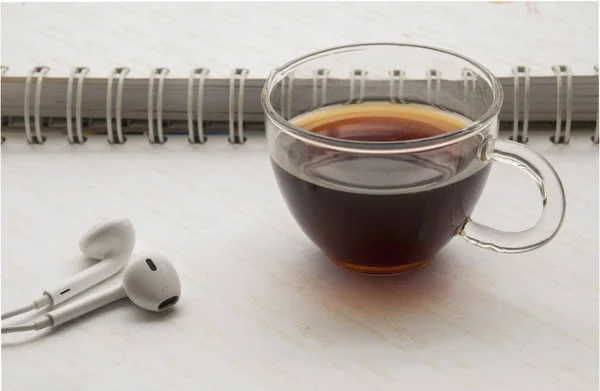 Café e fones de ouvido colocados em um notebook — Fotografia de Stock