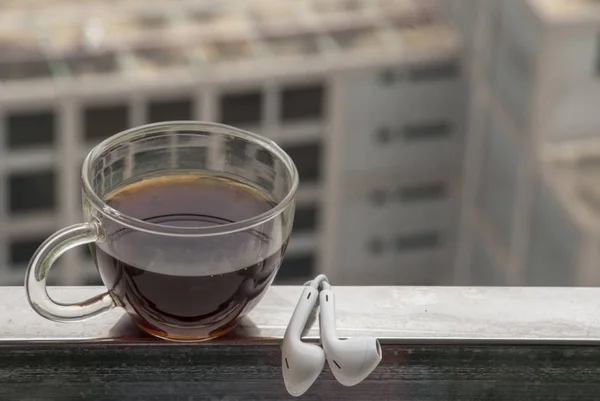 Gorąca kawa i słuchawki umieszczone na balkonie — Zdjęcie stockowe