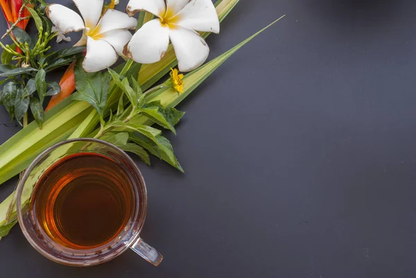 1 tasse de thé et une variété de fleurs placées sur une table noire — Photo
