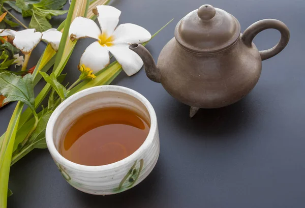 Conjunto de chá e flor em uma mesa preta — Fotografia de Stock