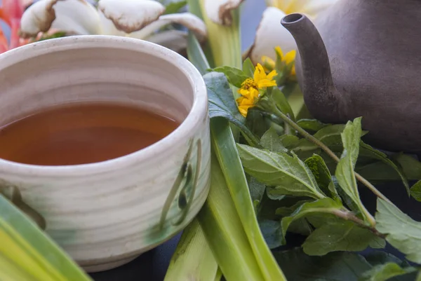 お茶セットと黒いテーブルの上の花 — ストック写真